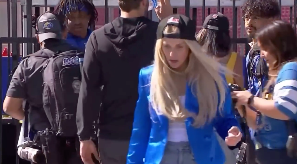 Matthew Stafford walks away while his wife Kelly brings the photographer