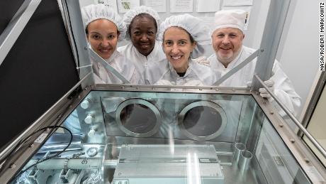 The processing team, including (from left) Charis Krysher, Andrea Mosie, Juliane Gross and Ryan Zeigler at NASA's Johnson Space Center, stands in front of the newly opened sample.