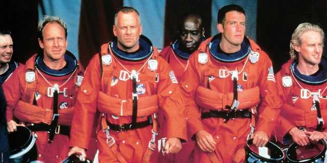 Steve Buscemi, Will Patton, Bruce Willis, Michael Clarke Duncan, Ben Affleck, and Owen Wilson walk in NASA uniforms in a scene from the movie "disaster," 1998. 