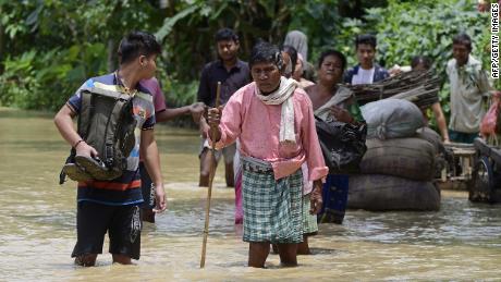 People walk in flood waters in Nagoon district of the Indian state of Assam on May 18.