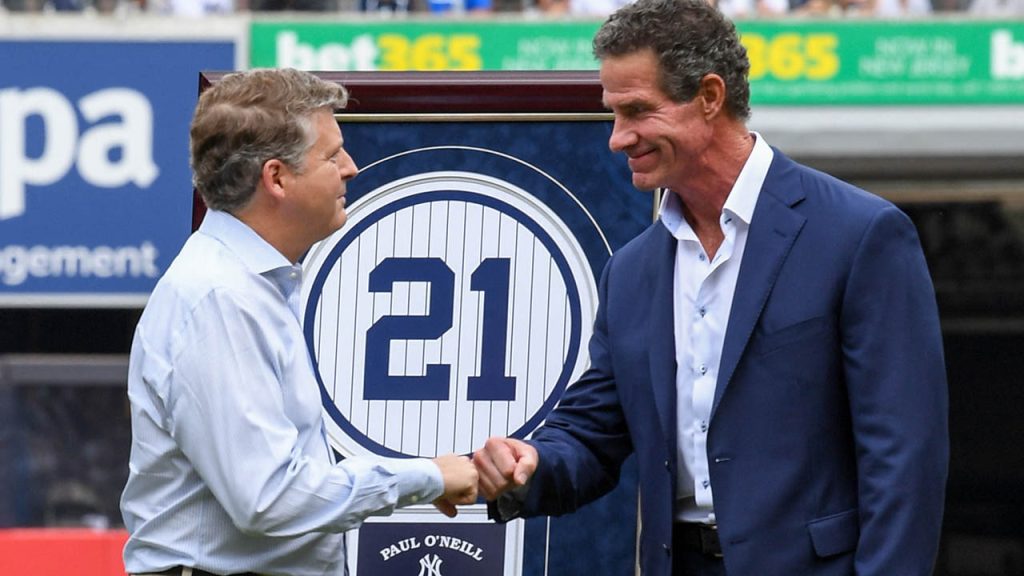 New York Yankees former player Paul O’Neill fist bumps owner Hal Steinbrenner during a ceremony to retire his number before the game between the New York Yankees and Toronto Blue Jays at Yankee Stadium August 21, 2022, in New York.