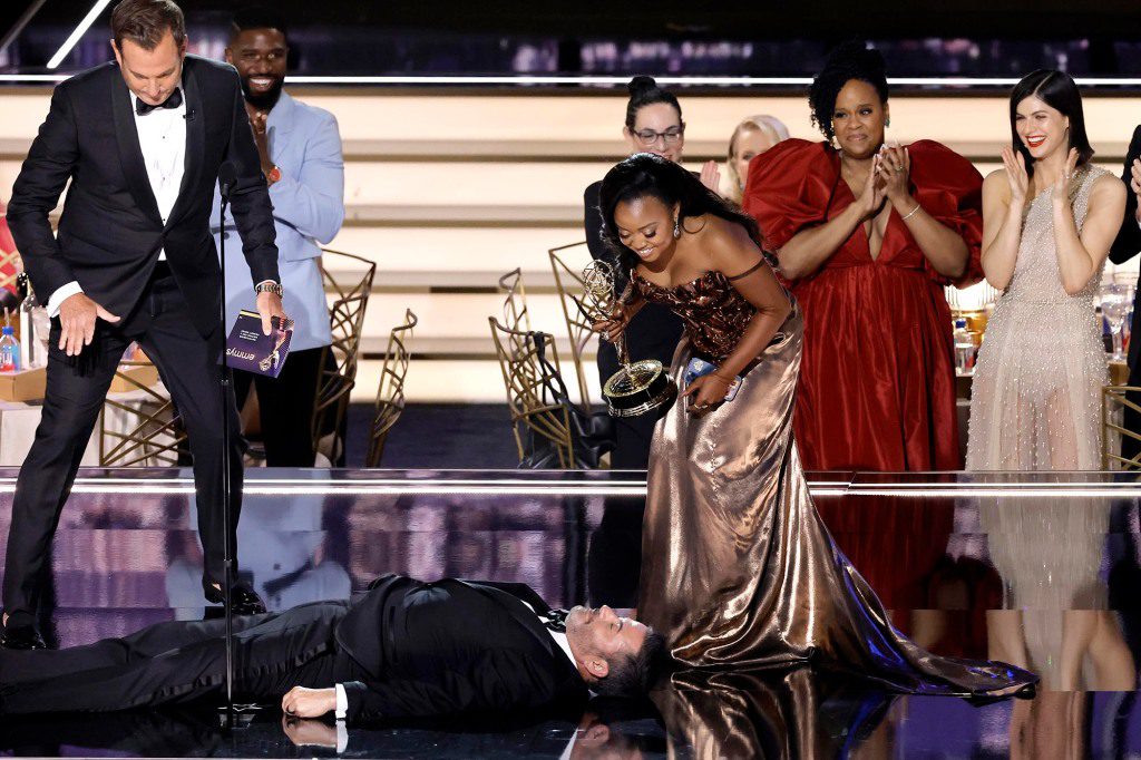 Quinta Brunson (R) accepts outstanding writing for a comedy series for "Abbott Elementary" From Will Arnett (left) as Jimmy Kimmel lies on stage during the 74th Primetime Emmys Awards at Microsoft Theater on September 12, 2022 in Los Angeles, California. 