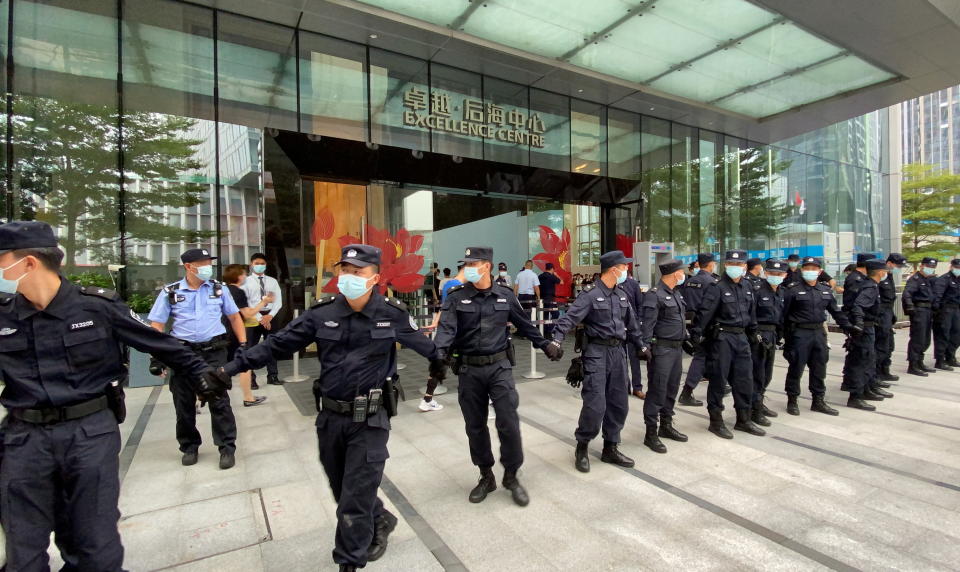 Security personnel form a human chain while guarding outside the Evergrande headquarters, where people have gathered to demand repayment of loans and financial products, in Shenzhen, Guangdong Province, China on September 13, 2021. REUTERS/David Kirton