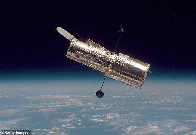 Hubble (pictured) caught the glow from about 340 miles above Earth's surface.  Astronomers who analyzed the images suggest that the glow could come from a dust ball made of comets